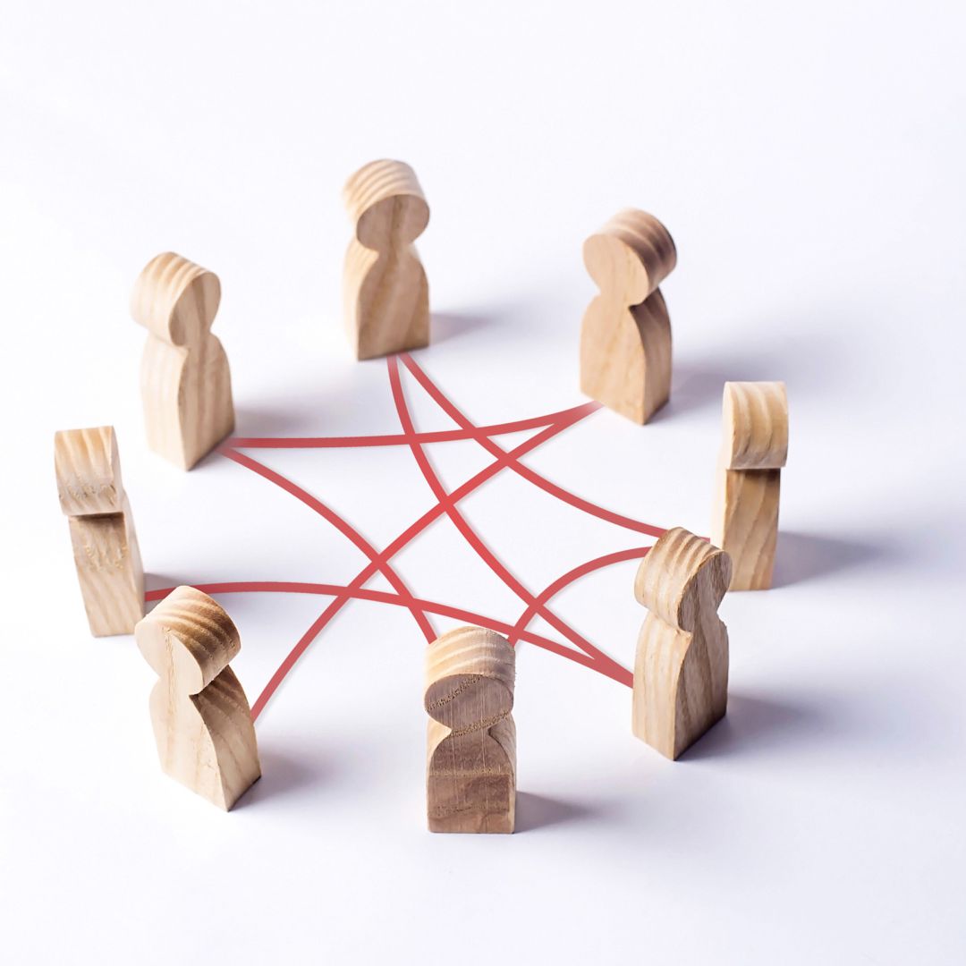 Wooden human-shaped cutouts connected to each other with red lines, representing relationships or networks.